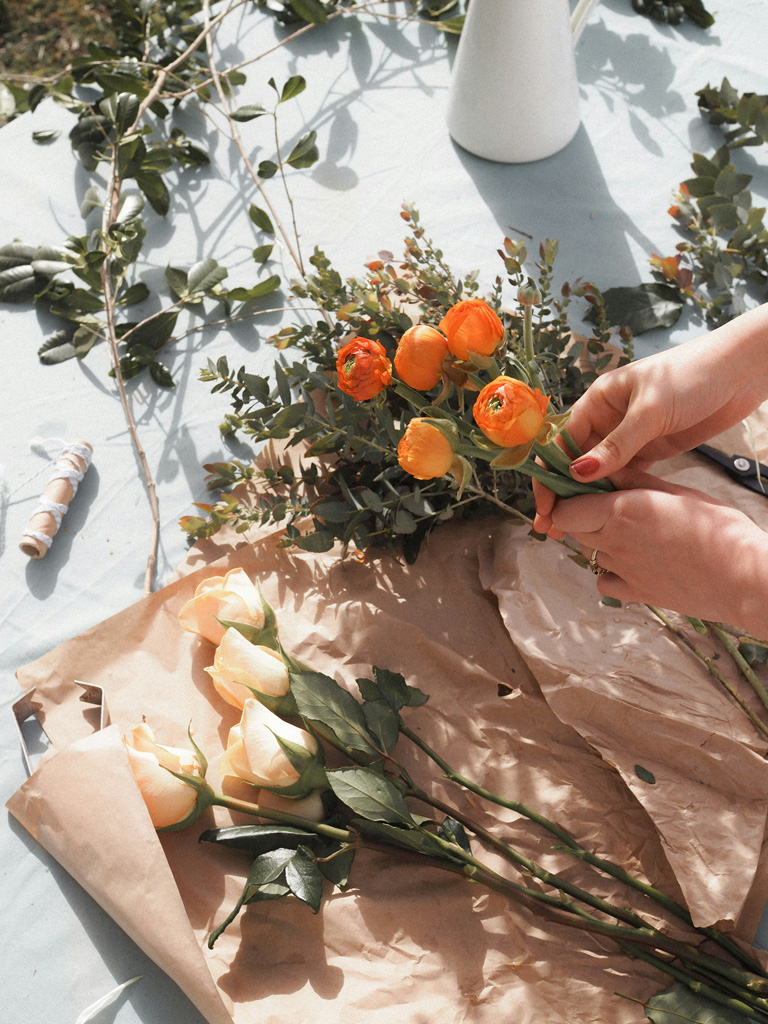Hands holding a bunch of orange flowers