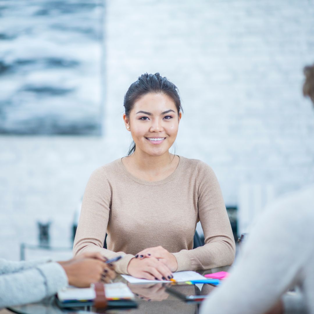 Woman smiling and sitting with two other people