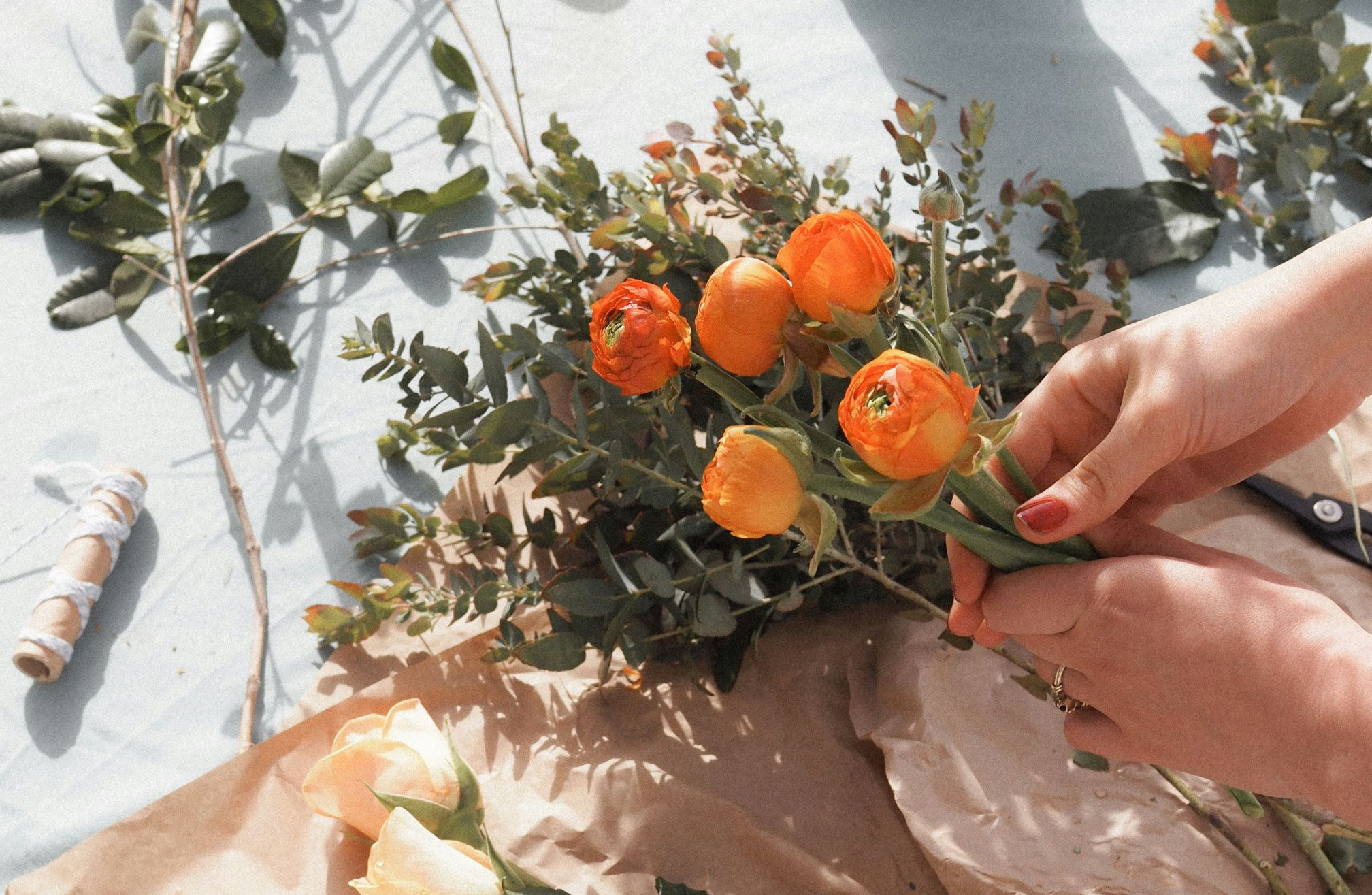 Hands holding a bunch of orange flowers