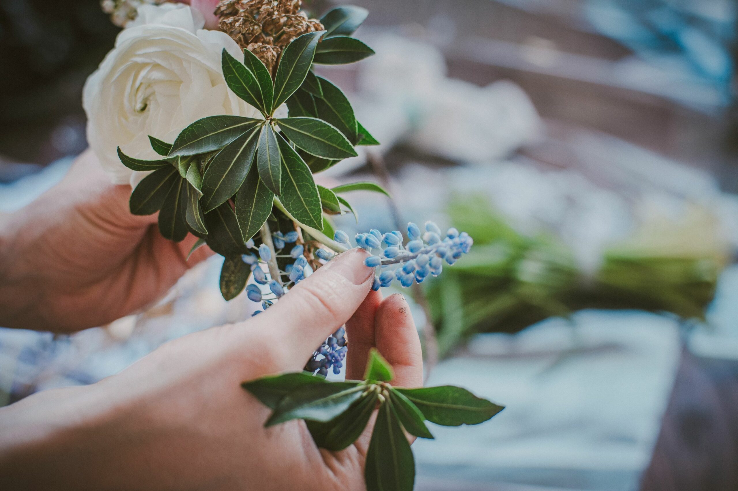 Florist making a flower arrangement with blue and white flowers